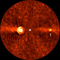 De ontdekte planeet Bèta Pictoris d (bij de witte pijl) op een opname van de Very Large Telescope. Het licht Bèta Pictoris is geblokkeerd (de witte ster). Links is de planeet Bèta Pictoris b zichtbaar. (c) ESO/B. Sutlieff, M. Bonse et al.