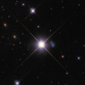 Hubble-opname van het kleine sterrenstelsel HIPASS J1131–31, alias ‘Kiekeboe’. Honderd jaar geleden ging het stelsel nog schuil achter de heldere ster links. © NASA, ESA, Igor Karachentsev (SAO RAS)