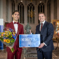 Minister Gouke Moes van Onderwijs, Cultuur en Wetenschap overhandigt prijswinnaar Martijn Oei het bronzen beeld van Christiaan Huygens en de bijbehorende cheque. © Paul Voorham