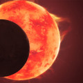 Deze artist’s impression toont de planeet TRAPPIST-1 d, terwijl deze voor zijn ster langs beweegt, met rechts de beide andere planeten van dit stelsel. © NASA, ESA, CSA, Joseph Olmsted (STScI)
