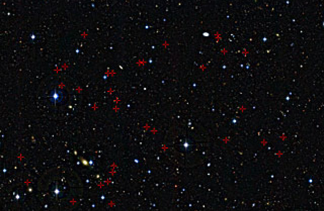 Dit kijkje in een piepklein hemelgebied in het sterrenbeeld Cetus (Walvis) toont een selectie van verre sterrenstelsels, aangeduid met rode kruisjes, die zijn gebruikt voor een nieuw onderzoek van de eetgewoonten van jonge sterrenstelsels-in-de-groei. Elk