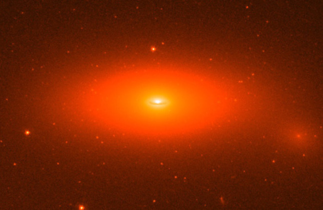 Het lensvormige sterrenstelsel NGC 1277. Dit compacte sterrenstelsel bevat één van de zwaarste centrale zwarte gaten tot op heden gedetecteerd. De massa van dit zwarte gat is gelijk aan 17 miljard zonsmassa's en maakt 14% uit van de totale massa van het