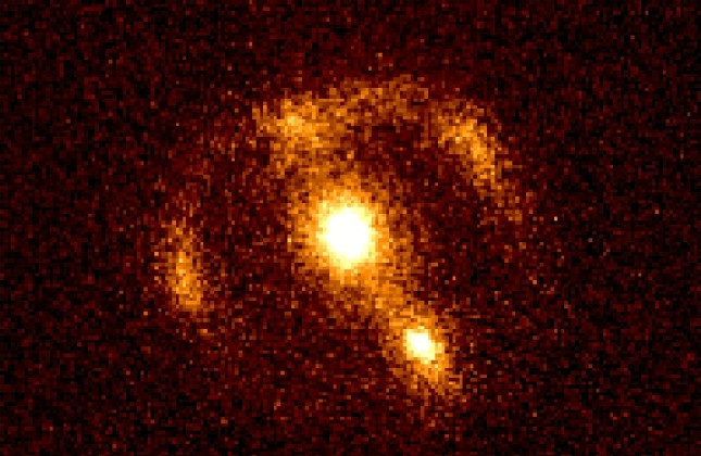 Rondom het melkwegstelsel geassocieerd met radiobron 3C220.3 (in  het midden van deze CCD-foto, gemaakt met de 10-m Keck-telescoop op Hawaï) is een ring van straling te zien. De ring is afkomstig van een ver weg gelegen melkwegstelsel-in-wording, en is h