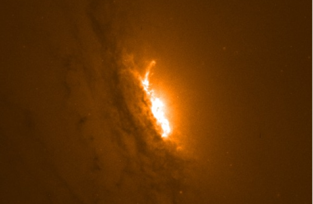Het centrale deel van het sterrenstelsel IC5063 zien, zoals waargenomen met Hubble Ruimtetelescoop. Het heldere gedeelte in het midden toont het gebied waar de jets, aangedreven door het superzware zwarte gat, het moleculaire gas uit het sterrenstelsel dr