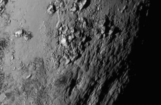 Detailfoto van een gebied in de buurt van de evenaar van Pluto waar bergen van 3500 meter hoog te zien zijn. De NASA-ruimtesonde New Horizons maakte de foto op 14 juli tijdens zijn scheervlucht langs de dwergplaneet. Credit: NASA/JHU APL/SwRI