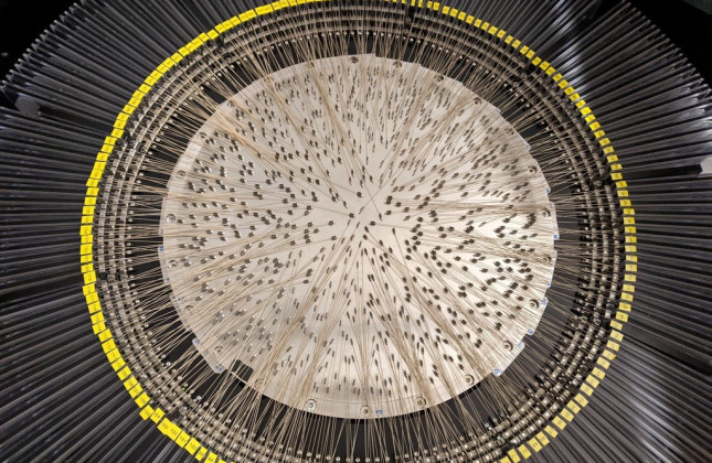 Close-up of the heart of WEAVE. Seven hundred of the 950 glass fibres were meticulously positioned by two robots that are outside the frame. The yellow ring is around 60 centimetres in diameter. (c) Gavin Dalton/Oxford University/STFC