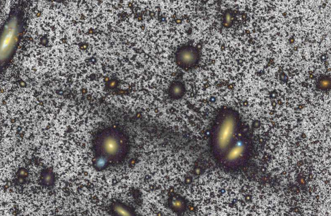 De zwarte streep is de nieuw ontdekte Giant Coma Stream. Deze streep is tien keer zo lang als onze Melkweg en bevindt zich op zo'n 300 miljoen lichtjaar van ons vandaan tussen sterrenstelsels (de gele vlekken). (c) William Herschel Telescope/Román et al.