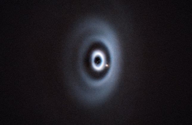 De pasgeboren planeet WISPIT 2b eet zich een weg door zijn stoffige ‘wieg’ terwijl hij rond zijn moederster draait.  Credit: ESO/R. F. van Capelleveen et al.