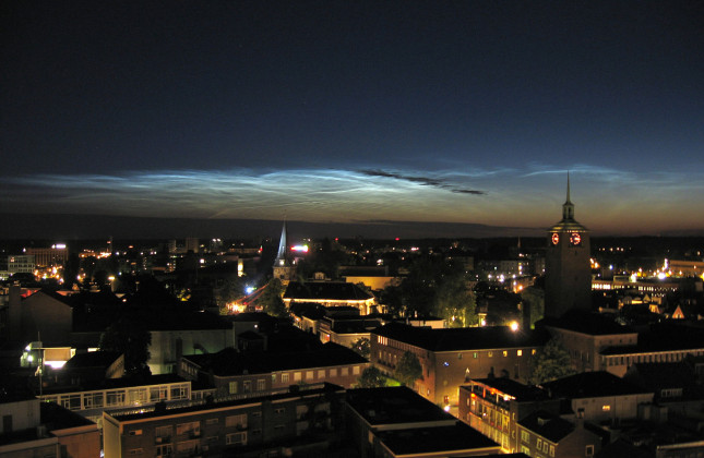 In de maanloze nachten rond het begin van de zomer heb je kans om lichtende nachtwolken te zien. Hier een foto van het verschijnsel boven Enschede. (c) Door Ruudgreven, CC BY-SA 3.0 [via Wikimedia]