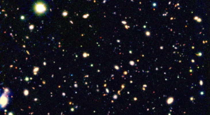 Een kleurenmontage van de meest gevoelige opname van het heelal, gemaakt door Ivo Labbé. De foto laat veel rode sterrenstelsels zien. Drie daarvan zijn linksboven uitvergroot weergegeven. Dit zijn relatief oude sterrenstelsels in een jong heelal. Dit bee