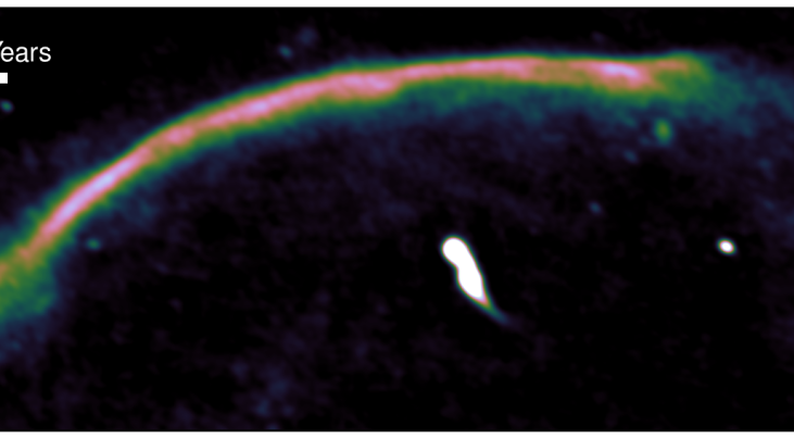 Een met een radiotelescoop gemaakte afbeelding van het bovenste stuk van het cluster van sterrenstelsels 'The Sausage'. De schokgolf is zichtbaar als een helder roze, worstvormige boog (vandaar ook de naam 'The Sausage', het worstje). De schokgolf ontston