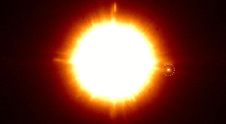 De dubbelster CS Cha met daarbij in de gestippelde cirkel de nieuw ontdekte begeleider. Met een muisklik wordt een afbeelding zichtbaar die gemaakt is met speciale polarisatiefilters die stofschijven en exoplaneten tonen. De begeleider lijkt een eigen sto