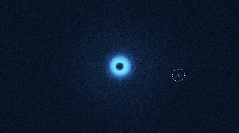 Een infrarood-afbeelding van de dubbelster en de nieuw ontdekte begeleider, maar nu bekeken met speciale polarisatiefilters die stofschijven en exoplaneten zichtbaar maken. De begeleider lijkt een eigen stofschijf te hebben. (c) C. Ginski & SPHERE